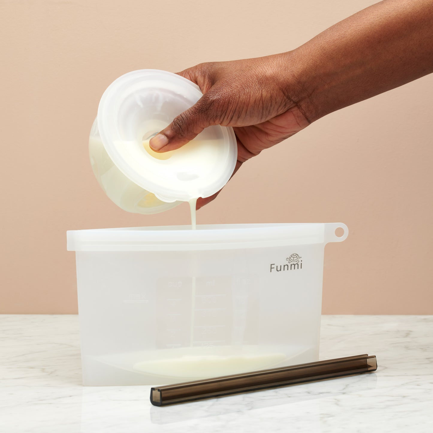 Funmi Wearable Single Electric Breast Pump pouring into milk storage bag
